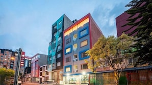 A multi-story hotel with a modern design, featuring a mix of colors on the facade. - Hotel Budhha Resort (Bogotá)