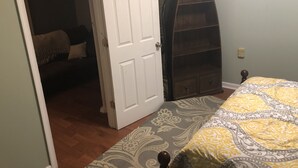 A bedroom with a bed, a wardrobe, and a door leading to another room. - Travel Nurses (Madison Heights)