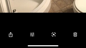 A bathroom with a shower, a toilet, and a small shelf with towels. - Travel Nurses (Madison Heights)