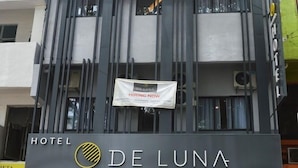 A hotel entrance with a banner for an opening promotion, a 'Delux Hiring Now' sign, and a 'Hotel De Luna' sign. - De Luna Hotel Sri Petaling (Kuala Lumpur)
