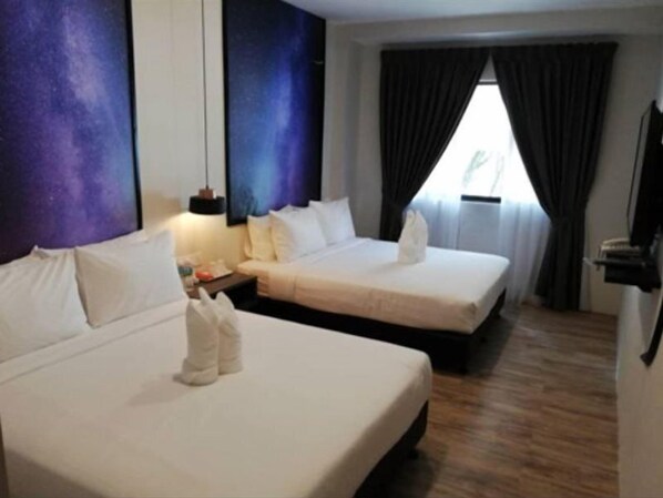 Une chambre d’hôtel avec deux lits, une table de chevet, une lampe et une fenêtre avec des rideaux.