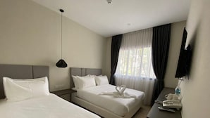 A hotel room with two beds, a desk with a phone, and a TV mounted on the wall. - De Luna Hotel Sri Petaling (Kuala Lumpur)