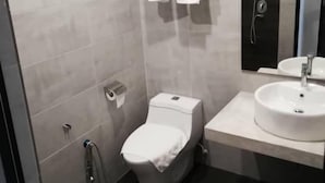 A modern bathroom with a toilet, a sink, and a shower. - De Luna Hotel Sri Petaling (Kuala Lumpur)