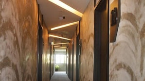 A long, narrow hallway with patterned walls and a carpeted floor. - De Luna Hotel Sri Petaling (Kuala Lumpur)