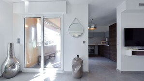 Una cocina moderna con una isla grande, un comedor con un banco y un espejo grande en la pared.