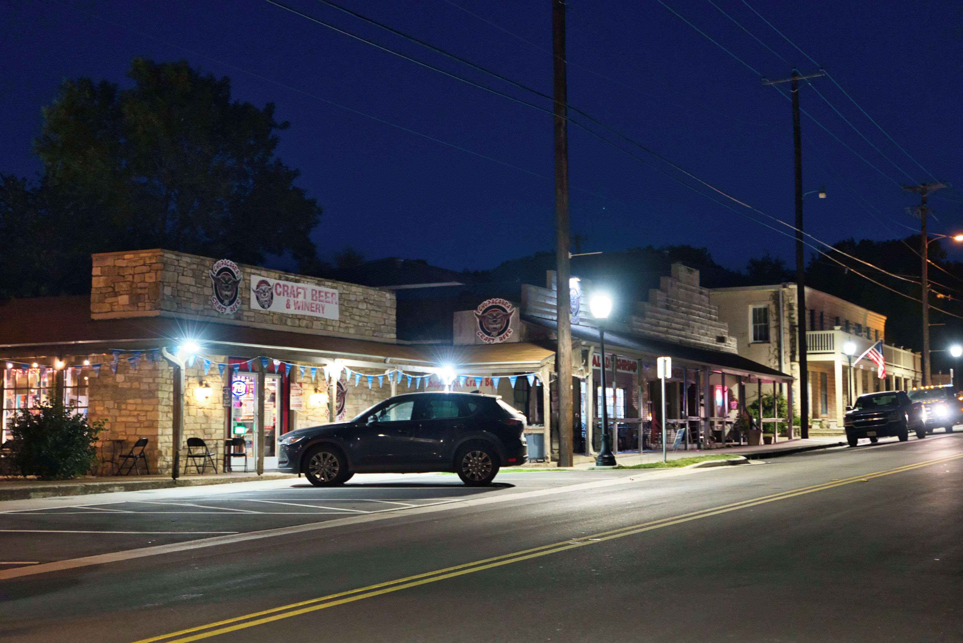 A street view at night with a building labeled 'CRAFT BEER & WINERY.'