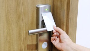 A hand inserting a card into a door lock mechanism. - Van Giang Hotel (Ninh Binh)