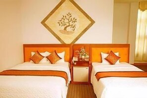 A hotel room with two beds, a wooden headboard, a nightstand, and a wall-mounted artwork of a tree. - Van Giang Hotel (Ninh Binh)