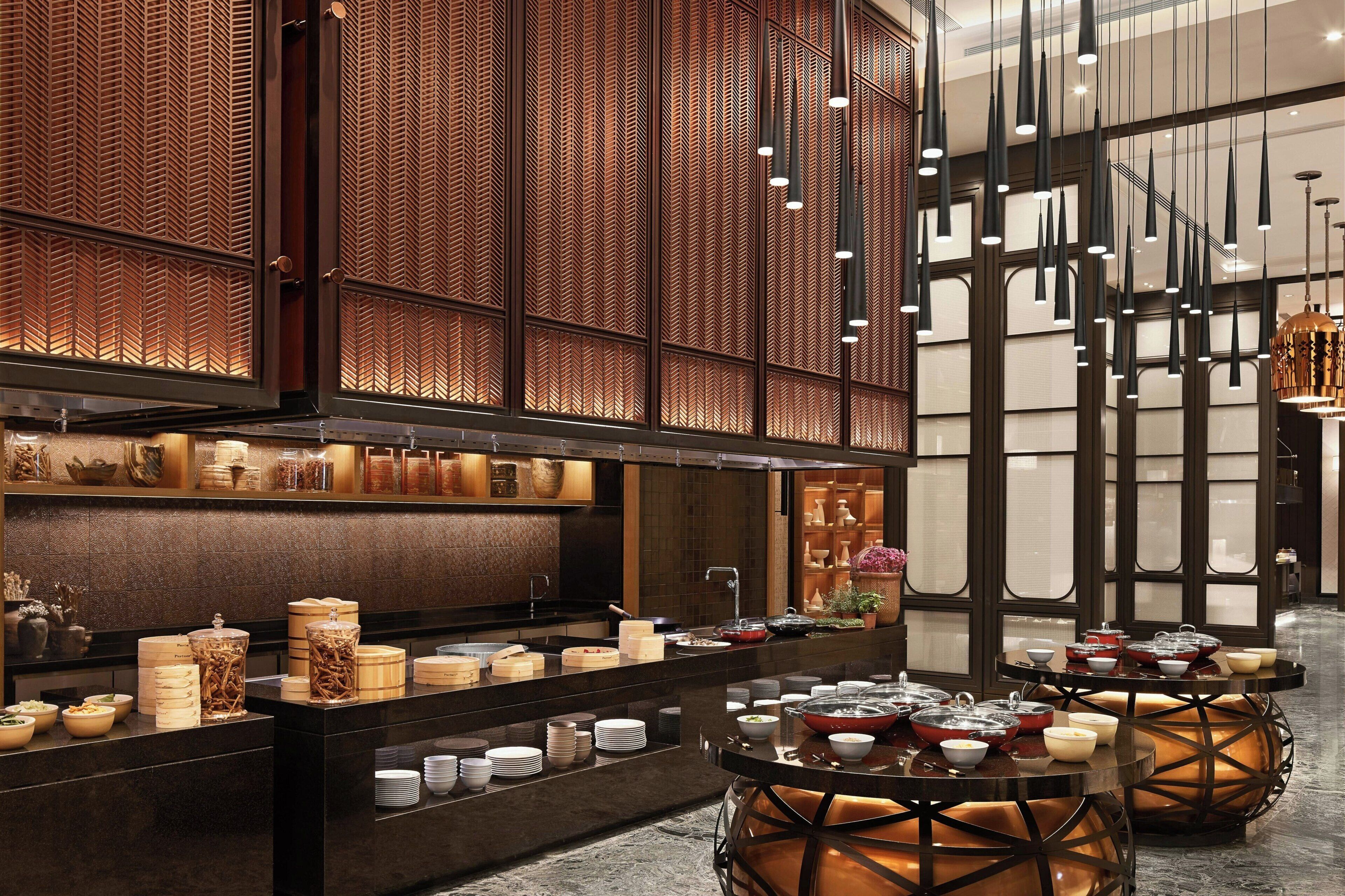 Ein modernes Interieur mit einer Rezeption, einem Buffetbereich und dekorativer Beleuchtung.