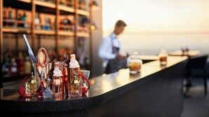 A bar area with various bottles and a person in the background. - The Ritz-carlton Pune (Pune)