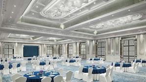 A large, well-lit conference room with round tables and white chairs, featuring ornate ceiling designs and large windows. - The Ritz-carlton Pune (Pune)