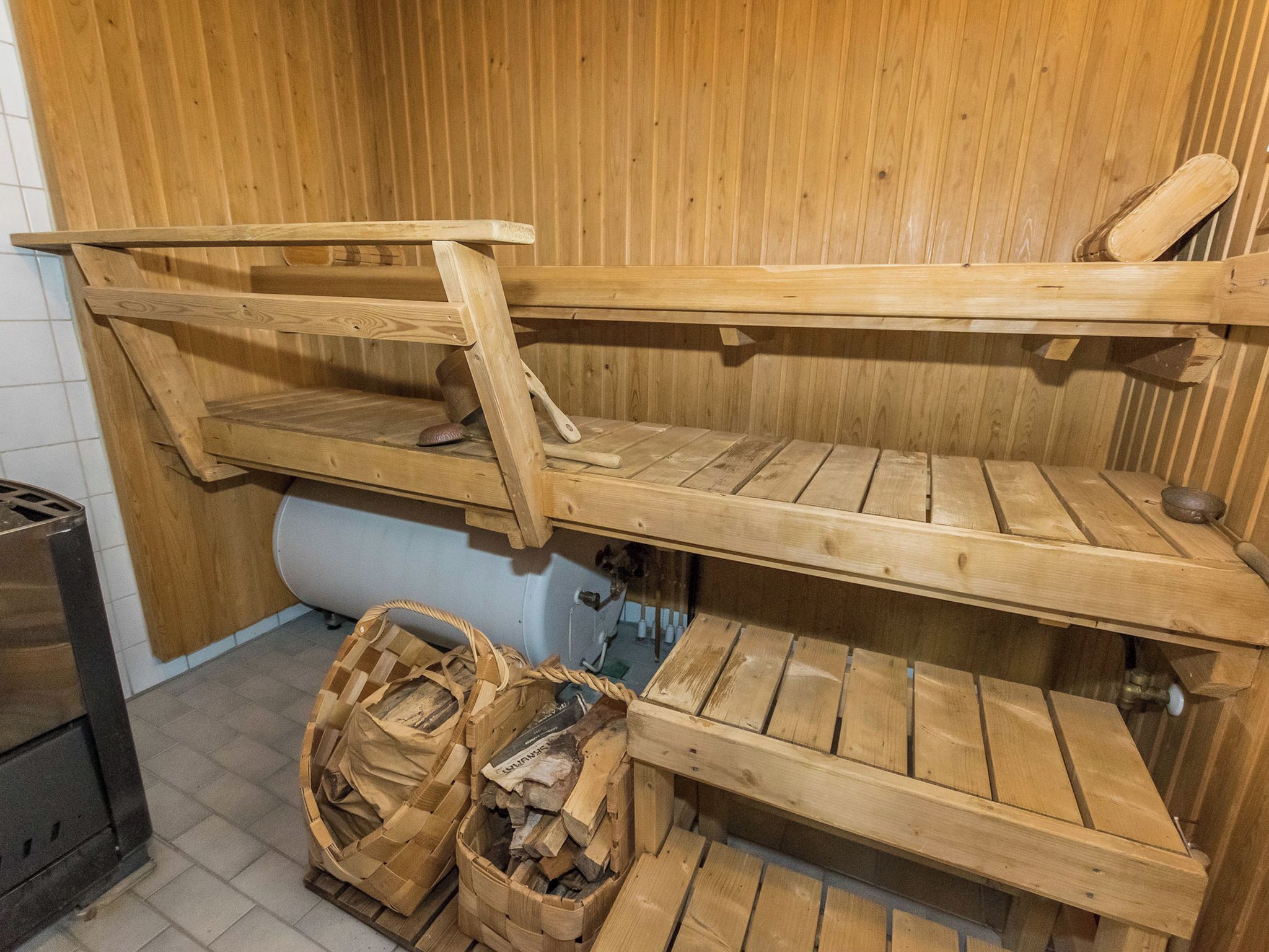 Una sauna con bancos de madera y pared de madera.