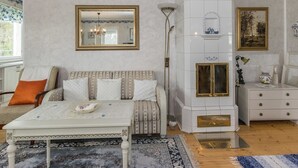 A living room with a sofa, a coffee table, a fireplace, and a mirror on the wall.