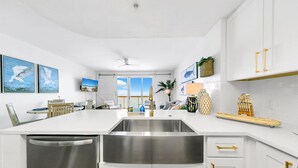 A modern kitchen with white cabinetry, stainless steel appliances, and a central island.