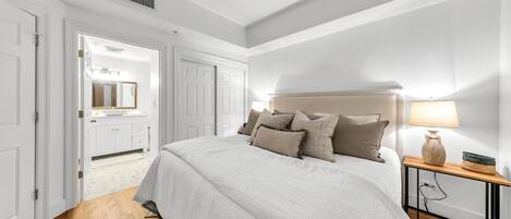 A bedroom with a bed, a nightstand, a lamp, and a ceiling fan.