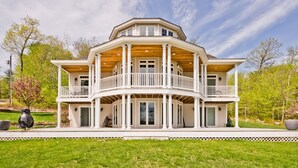 Ein großes, zweistöckiges Haus mit breitem Veranda und mehreren Balkonen.