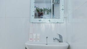 Ein Badezimmer mit einem weißen Waschbecken, einem Spiegel und drei OYO Dentalpflegeprodukten an der Wand.