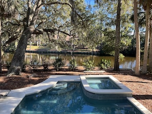 A swimming pool with a view of a lake and trees.