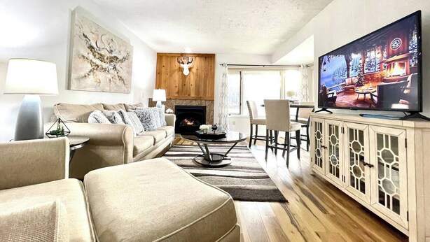 Ein Wohnzimmer mit Kamin, Fernseher und Holzboden.