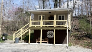 Eine Hütte mit Veranda, Treppe und Bank.