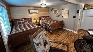 Ein Zimmer mit zwei Holzbetten, einem Esstisch und einem Stuhl.