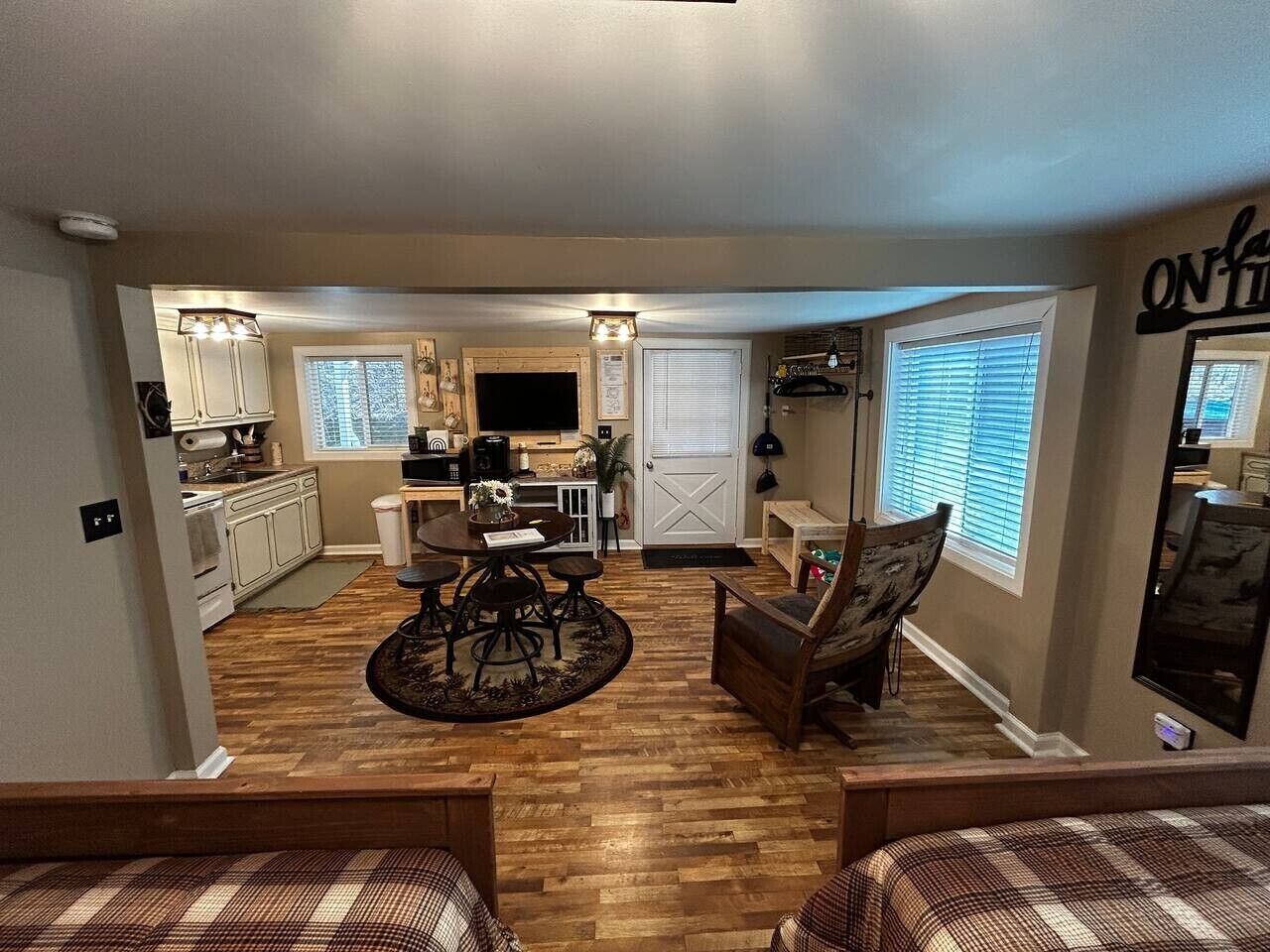 A compact kitchen with a dining area, a small seating space, and a window with blinds.