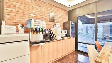Cozinha moderna com parede de tijolos, cafeteira e geladeira.