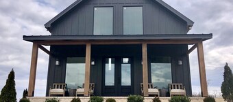 Cottage with panoramic hilltop views and stocked pond on 80 acres. 