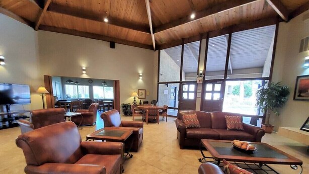 Un'ampia hall con divani in pelle, un tavolino da caffè e un televisore.