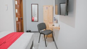 Une chambre d’hôtel comprenant un lit, un bureau, une chaise, une armoire et un téléviseur.