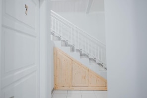 A staircase with a wooden handrail and a white wall.
