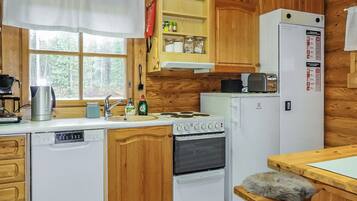 A compact kitchen with wooden cabinets, a white dishwasher, a stove, and a refrigerator.