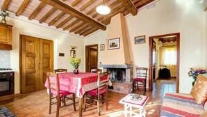 Uma sala de estar aconchegante com lareira, móveis de madeira e piso de azulejo.