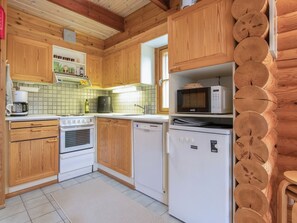 Eine Küche mit Holzschränken, einem Herd, einer Mikrowelle und einem Geschirrspüler.