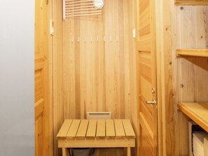 A wooden sauna with a bench and a ventilation system.