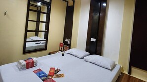 A hotel room with a bed, a window with a view, a bedside table, and a nightstand. - Hotel Sogo Makati Ave. (Makati)