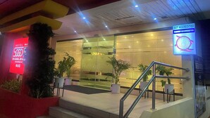 A hotel entrance with a glass facade, a staircase, and potted plants. - Hotel Sogo Makati Ave. (Makati)