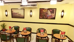 A restaurant interior with round tables and green chairs, each with a menu sign. - Hotel Sogo Makati Ave. (Makati)