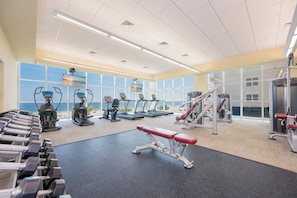 Un gimnasio con cintas de correr, máquinas de pesas y mancuernas.