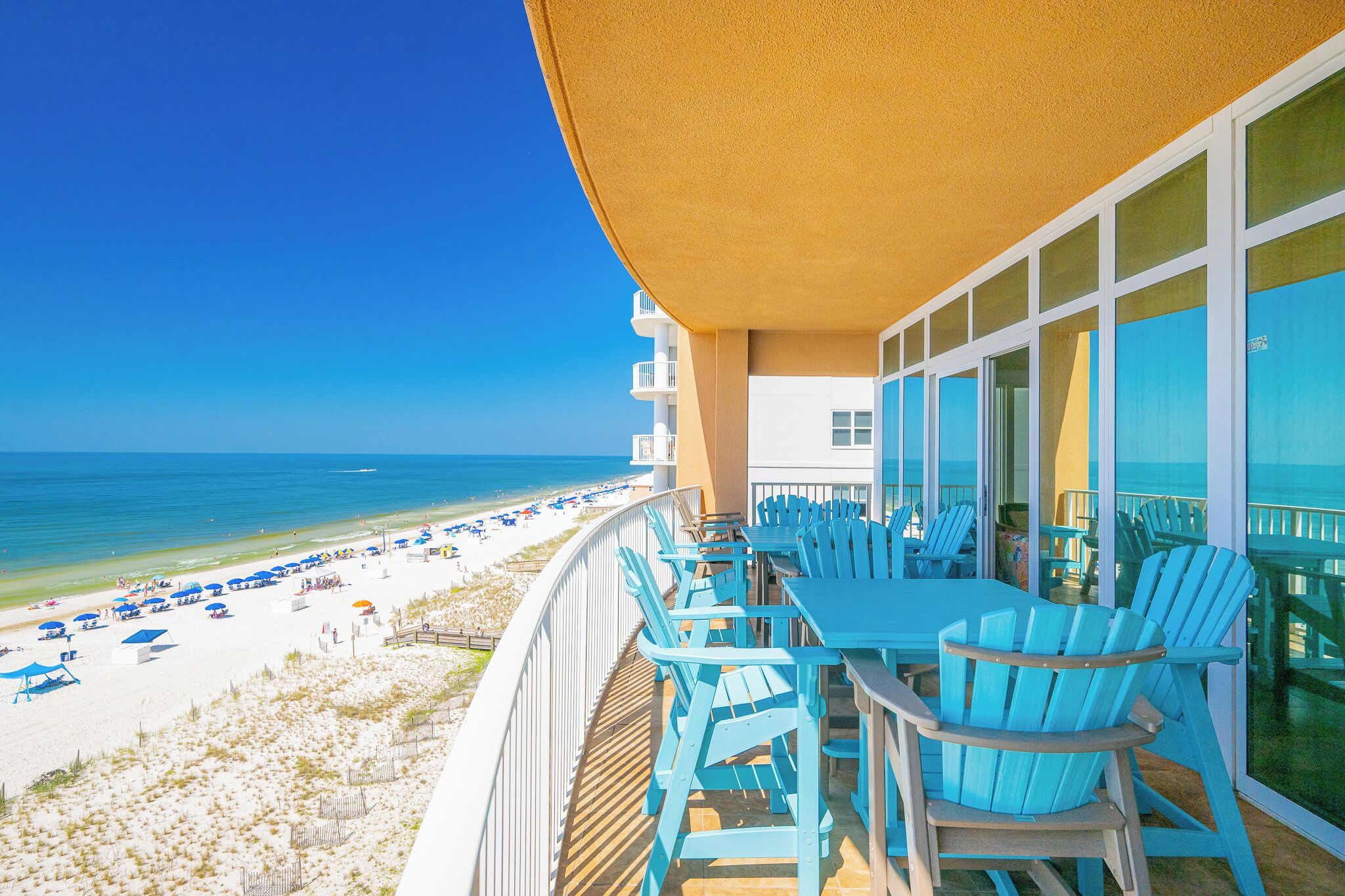 Een balkon met uitzicht op strand en zee.