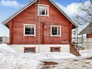 Un edificio de madera roja con un cartel que dice 'KIRUNA' y una escalera que lleva al tejado.