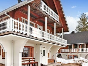 A two-story wooden building with a balcony, a door labeled 'PEN KIRUNA,' and a snow-covered ground. - Pieni kiiruna by Interhome (Hyrynsalmi)