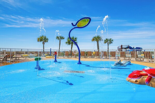 A water park with multiple water features, including fountains and a wave pool.