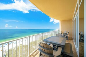 A balcony with a table and chairs overlooking a beach and ocean. - HIGH DEMAND ~ Two Bedroom ~ Phoenix Orange Beach 2!! (Orange Beach)