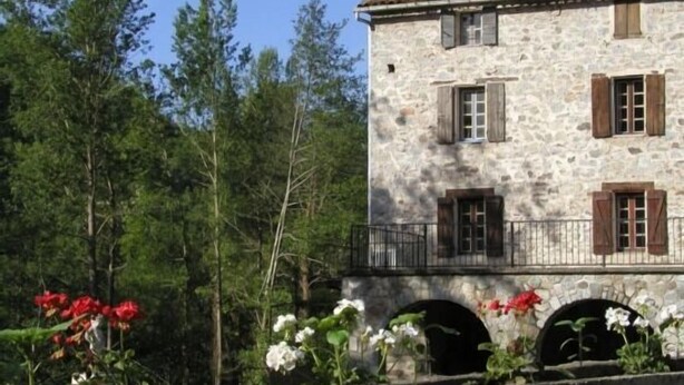 A stone building with multiple windows and shutters, surrounded by greenery and flowers. - Self catering Mas Manyaques for 5 people (Tech)