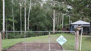 Zona tancada per una tanca amb un cartell que diu 'LAND FOR WILDLIFE' i una reixa metàl·lica.
