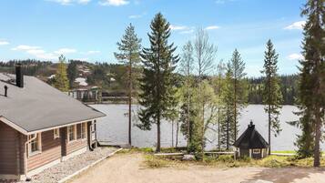 A lakeside view with a wooden building, a small cabin, and a dock extending into the water.