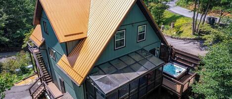 Una casa de dos plantas con un amplio balcón y un jacuzzi.