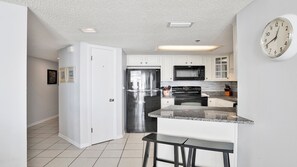 A modern kitchen with white cabinets, stainless steel appliances, and a granite countertop. - Gorgeous Gulf Front view @ Phoenix V, Outdoor Pool, Hot tub & Splash Pad!! (Orange Beach)
