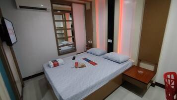 Une chambre à coucher avec un lit, une table de chevet et une chaise rouge.